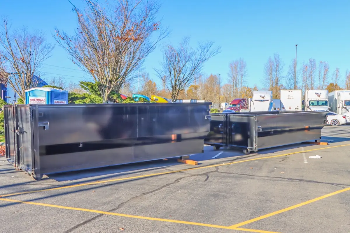 Professional dumpster rental service with roll-off container on residential driveway in West Orange